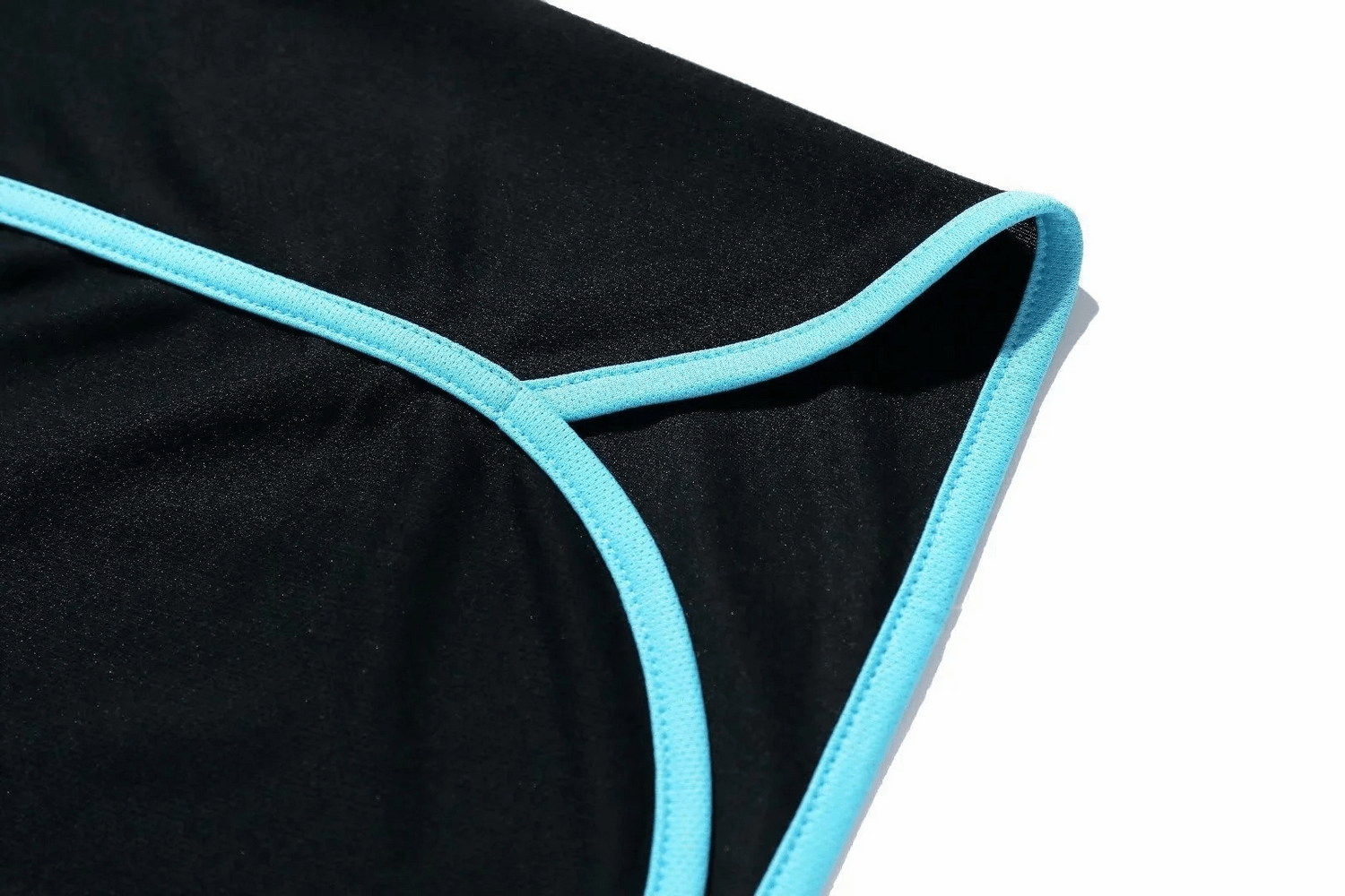 Close-up of blue-trimmed black athletic shorts, showcasing breathable, moisture-wicking fabric for men’s running gear.